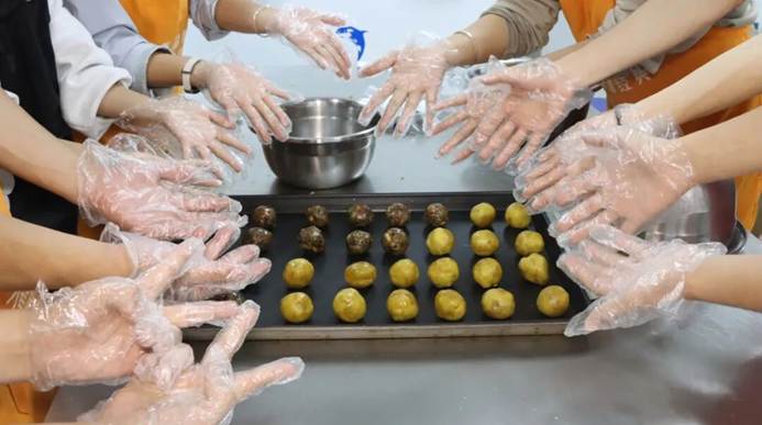 一群人在厨房里做食物 AI 生成的内容可能不正确。